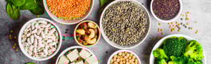 Ciotole con legumi, frutta secca e verdure su un tavolo: alimenti tipici di un’alimentazione sana e bilanciata, alla base del mindful eating.